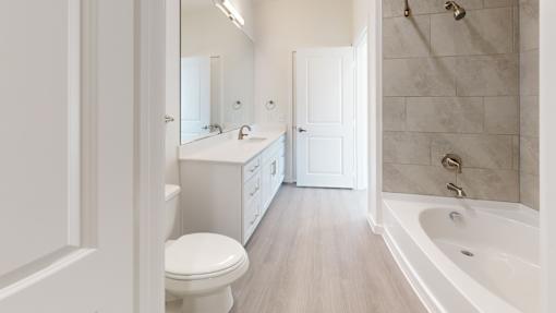 A white bathroom with a toilet, sink, and bathtub.