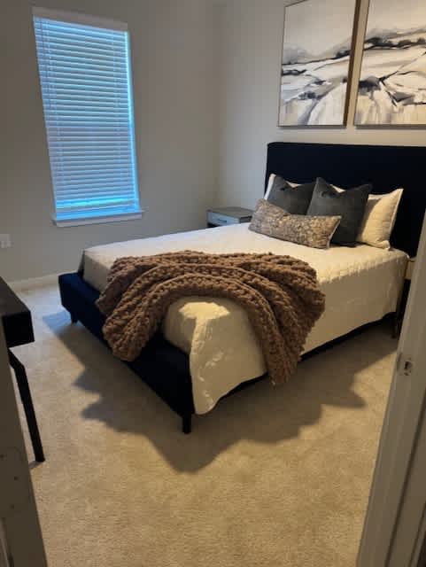 A bedroom with a bed covered in a brown blanket and pillows at Arden at Corinth, Corinth, TX 76210