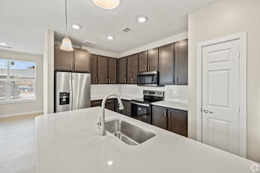 a kitchen with a sink and a refrigerator at Creekside at Grand Prairie, Grand Prairie, TX