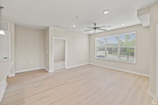 an empty living room with a large window and a ceiling fan at Creekside at Grand Prairie, Grand Prairie, 75052