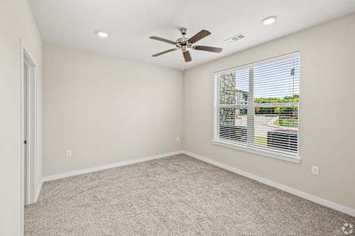 an empty living room with a ceiling fan and a window at Creekside at Grand Prairie, Grand Prairie, Texas, 75052