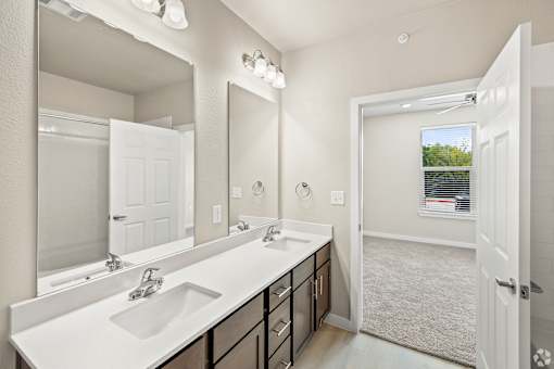 an empty bathroom with two sinks and a mirror at Creekside at Grand Prairie, Grand Prairie, Texas, 75052