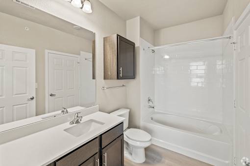 a bathroom with a shower sink and toilet and a mirror at Creekside at Grand Prairie, Grand Prairie, TX