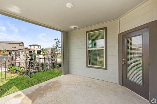the front porch of a home with a patio and a fence at Creekside at Grand Prairie, Grand Prairie, Texas
