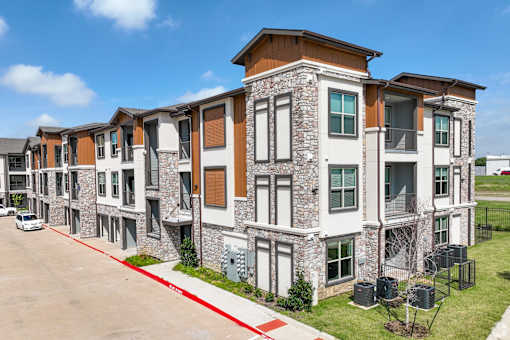 a row of apartment buildings on the side of a street at Creekside at Grand Prairie, Grand Prairie, Texas