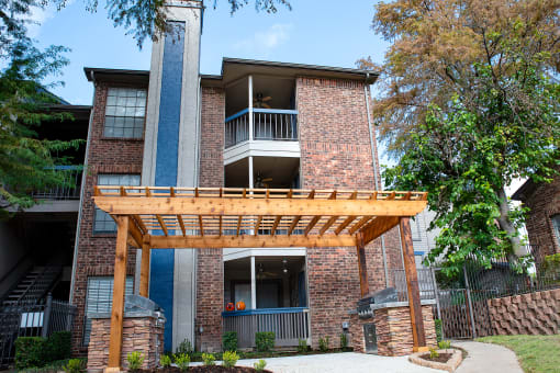 the view of a brick apartment building with a wooden porch at Infinity on the Mark, Dallas, TX, 75243