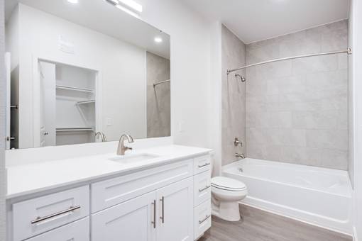 A white bathroom with a sink, toilet, and bathtub.