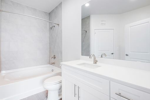 A white bathroom with a toilet, sink, and bathtub.