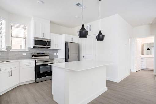 A modern kitchen with white cabinets and a central island.