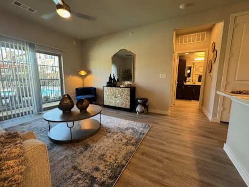 A living room with a sofa, a coffee table, and a mirror at Arden at Corinth, Corinth, TX