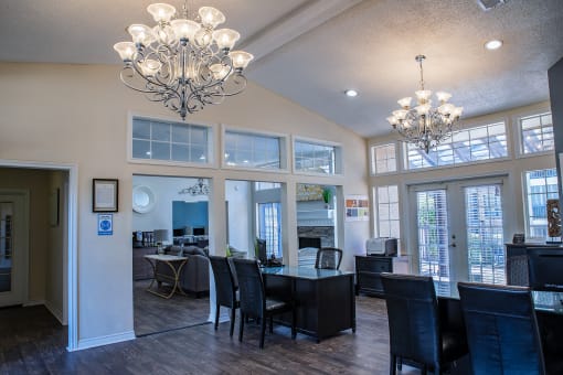 a dining room and living room with large windows and chandeliers at Infinity on the Mark, Dallas, TX