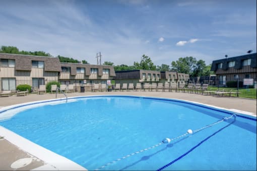 a large swimming pool with apartments in the background