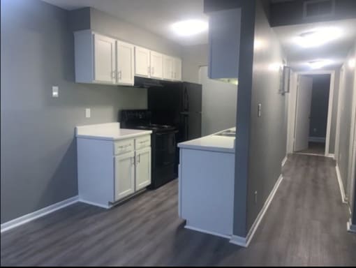 a kitchen with white cabinets and a black stove and