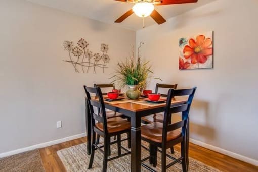 a dining room with a table and chairs and a ceiling fan