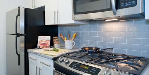 A modern kitchen with a stove, refrigerator, and microwave. at The Ellington Apartments, New York, NY, 10019