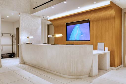 A reception area with a white reception desk and a television mounted on the wall.at 301E94, New York, NY 