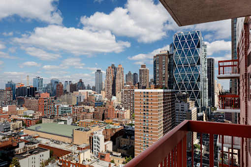 A cityscape with a mix of modern and older buildings, viewed from a high vantage point. at The Ellington Apartments, New York, 10019
