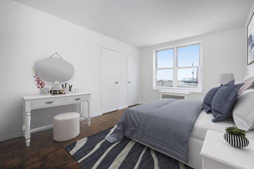 A bedroom with a bed, nightstand, and window.