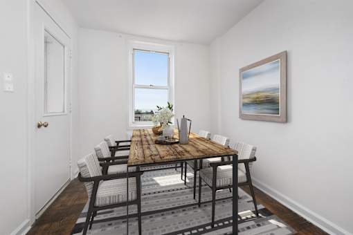 A dining room with a wooden table and chairs.