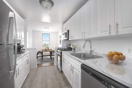 A modern kitchen with white cabinets and stainless steel appliances.