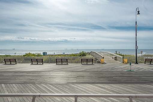 A wooden boardwalk with benches and a lamp post.