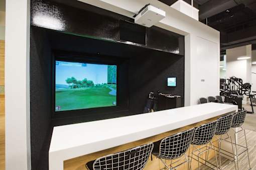A modern gaming setup with a large screen and multiple chairs.at 'The Metropolis', New York, NY 10017 