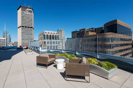 A rooftop patio with chairs and a table.at 'The Metropolis', New York, 10017