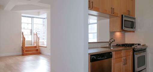 A kitchen with wooden cabinets and a stove top oven.at 21 West, New York 