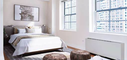 A bedroom with a large bed and a large window overlooking a cityscape.at 21 West, New York, NY 