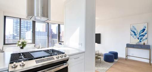 A modern kitchen with a stove top oven and a large window.at 301E94, New York 