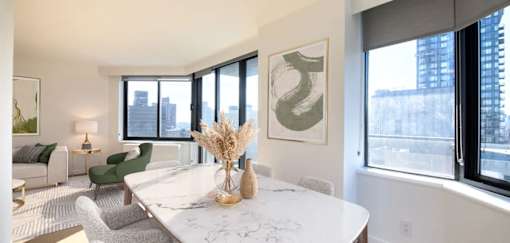 A modern dining room with a marble table and green chairs.at 301E94, New York 