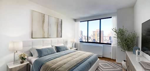 A bedroom with a large bed and a city view through the window.at 301E94, New York, 10128 