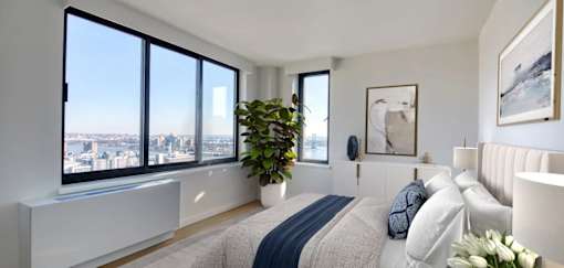 A bedroom with a large bed and a view of the city.at 301E94, New York, 10128 