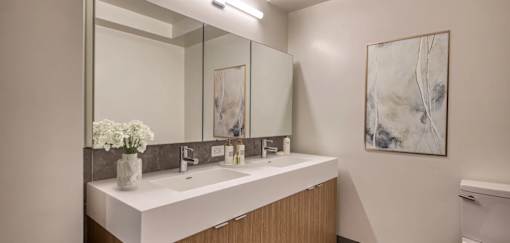 A bathroom with a white counter top and a large mirror.at 301E94, New York New York 