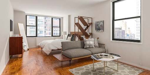 A living room with a grey couch and a coffee table.at Carnegie Mews, New York, NY 10019