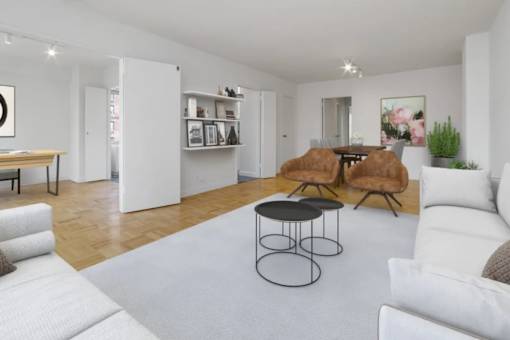 A living room with white furniture and a grey rug at The Caldwell Apartments, New York