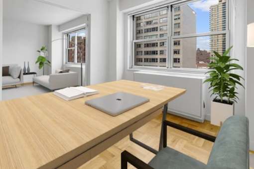 A laptop is on a wooden desk in a room with a window at The Caldwell Apartments, New York, 10028