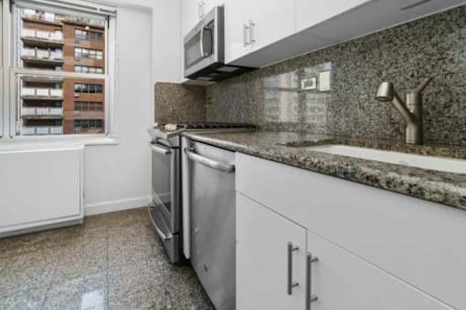 A kitchen with a dishwasher and a microwave at The Caldwell Apartments, New York, NY