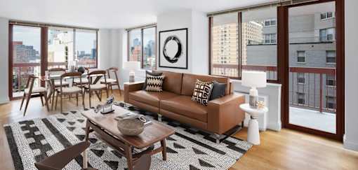A living room with a brown couch and a coffee table at The Ellington Apartments, New York, 10019