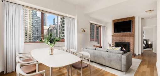 A living room with a fireplace and a flat screen TV at The Ellington Apartments, New York