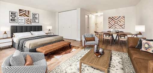 A modern bedroom with a large bed and a dining area in the background at The Ellington Apartments, New York, NY, 10019