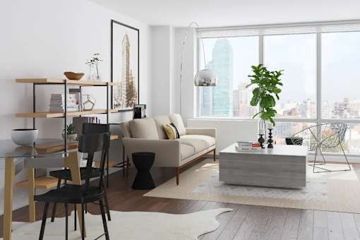 A modern living room with a large window overlooking a cityscape at The Maximilian Apartments, New York