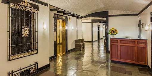 A hallway with a black and gold door and a red counter. at Sutton Collection Apartments, New York, NY, 10022