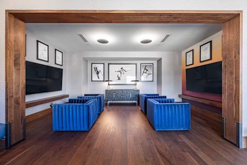 a conference room with blue chairs and a large screen tv