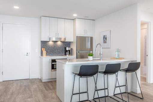 a kitchen with an island and three bar stools