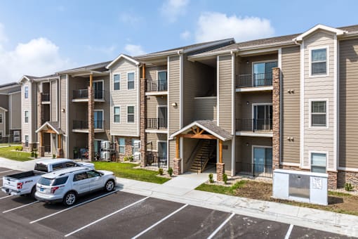A row of apartment buildings with a car parked in front.