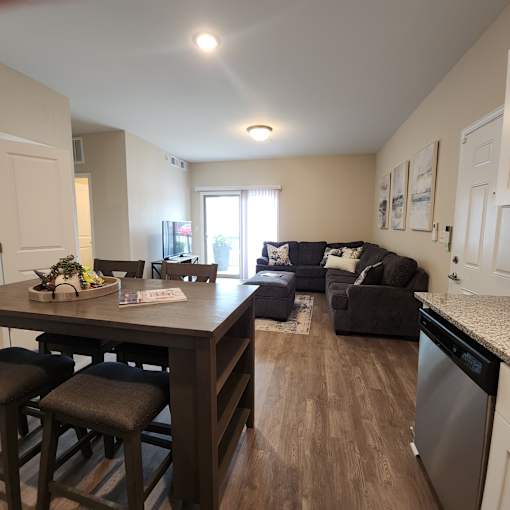 A kitchen with a dining table and chairs.