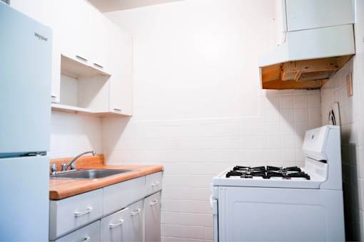 A white kitchen with a stove and sink.