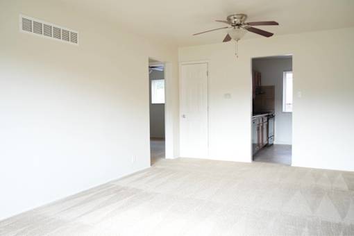 A room with a ceiling fan and a door.
