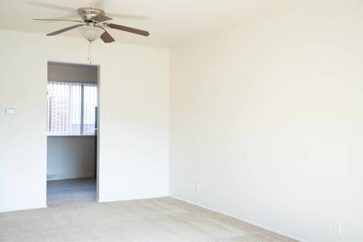 A room with a ceiling fan and a window.